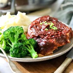 a plate with meat, broccoli and mashed potatoes