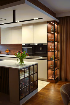 the kitchen is clean and ready to be used for dinner or party purposes, it has an island with glass shelves on both sides