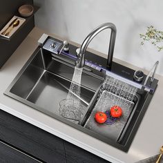 a kitchen sink with two tomatoes in it