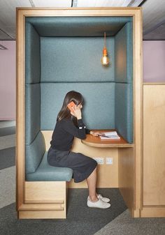 a woman sitting at a desk in an office cubicle with her head on the table