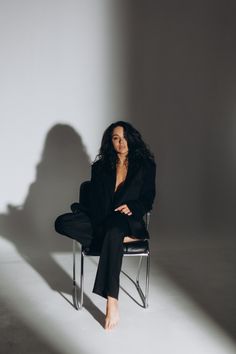 a woman sitting in a chair with her legs crossed