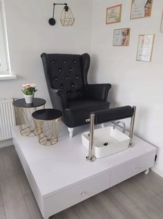 a black chair sitting on top of a white table