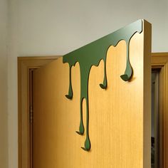 a wooden cabinet with green paint dripping down the front and side panels on it's sides