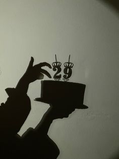 the shadow of a person holding a cake