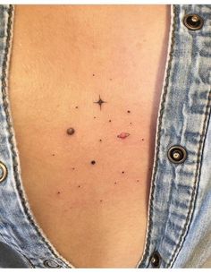 the back of a woman's stomach with black dots and stars on her chest