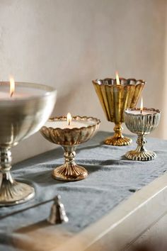 three silver candles are sitting on a table