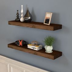 two wooden floating shelves with vases and books on them in the corner of a room