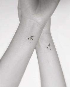 two wrist tattoos with stars on them