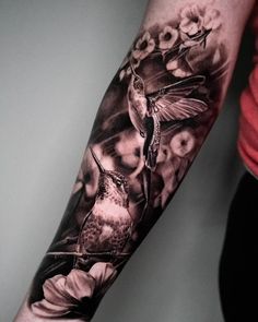 a woman's arm with a hummingbird and flowers on it