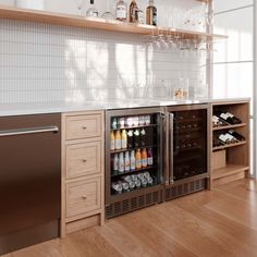 an open refrigerator in a kitchen with lots of bottles and glasses on the shelves next to it