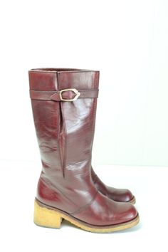 Vintage 70's Etienne Aigner burgundy leather boots.  Knee high.  Slightly rounded square toes.  Buckle at the calf.  Textured rubber sole.  Condition: Very good condition.  Only light wear.Brand: Etienne AignerMaterial: Leather upper, rubber soleSize: 5 1/2Length inside from heel to toe: 8 3/4 in.Heel width inside: 2 1/4 in.Ball outside: 2 7/8 in.Boot height: 11 1/2 in.Calf circumference: 12 1/2 in. Vintage Boots With Leather Sole And Square Toe, Vintage Leather Boots With Low Heel, Vintage Leather Heeled Boots With Low Heel, Retro Leather Boots With Square Toe, Retro Square Toe Leather Boots, Burgundy Leather Square Toe Boots, Retro Leather Knee-high Boots With Round Toe, Retro Knee-high Leather Boots, Vintage Boots With Leather Lining And Medium Width