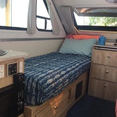 a small bed sitting inside of a bedroom next to a sink and stove top oven