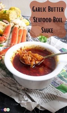 a white bowl filled with seafood sauce on top of a newspaper next to crab legs