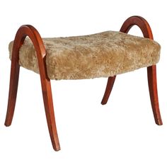 a wooden bench with a furry seat cushion on it's backrest and curved legs