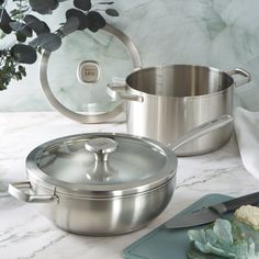 a stainless steel pot and pan on a marble counter