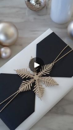 a black and white christmas card with a gold snowflake decoration on the front