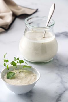 a glass jar filled with yogurt next to a small bowl full of yogurt