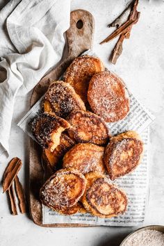 cinnamon buns on a cutting board with cinnamon sticks