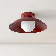 a red light hanging from the side of a white wall