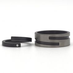 two rings with black bands are sitting next to each other