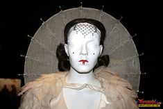 a white mannequin with red lips and headdress