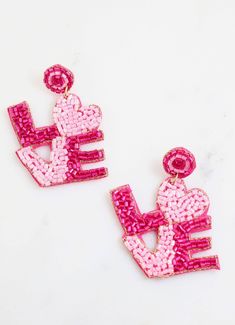 This beaded LOVE earring is so festive! It has hot pink and light pink beading on a post back and is felt covered on the back. Dimensions: 2.5" long by 1.75" wide Pink Fun Dangle Jewelry, Fun Pink Dangle Jewelry, Fun Pink Heart-shaped Jewelry, Pink Fun Jewelry For Party, Pink Fun Party Jewelry, Fun Pink Party Jewelry, Handmade Pink Beaded Earrings For Party, Pink Jewelry With Colorful Beads For Valentine's Day, Handmade Fun Pink Jewelry