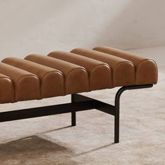 a brown bench sitting on top of a carpeted floor