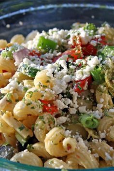 a bowl filled with pasta and vegetables covered in cheese