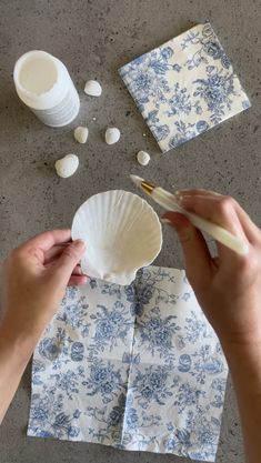 someone is making paper napkins out of blue and white flowers