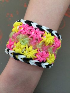 a person's arm with a bracelet made out of different colored rubber bands and beads