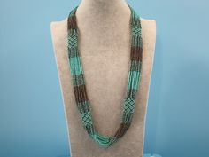 This striking 24" turquoise necklace with accented bronze beads was hand beaded by one of our group of Mayan women in the village of Santiago Atitlan, Guatemala. Various strands of Czech beads form intricate patterns creating a stunning and unique look. This is a convenient "slips-over-the-head" necklace that does not require any closure clasps.  Each necklace is individually hand made; therefore there may be a slight variance in the placement and color of the natural stones and beads 32" total Artisan Turquoise Necklaces With 108 Beads, Artisan Turquoise Necklace With 108 Beads, Handmade Southwestern Green Beaded Necklace, Green Handmade Southwestern Beaded Necklace, Artisan Handwoven Turquoise Jewelry, Handwoven Turquoise Round Bead Jewelry, Artisan Turquoise Handwoven Jewelry, Traditional Turquoise Handwoven Jewelry, Southwestern Handwoven Turquoise Jewelry