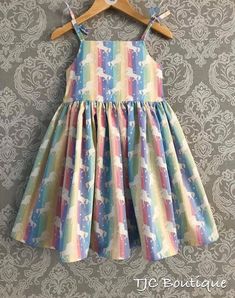 A beautiful Sun dress with tie straps and a comfortable elasticated back. Rainbow unicorn 100% cotton , knee length and a full skirt perfect for twirling. The bodice is fully lined and comes with a matching hair bow accessory  Please don't hesitate to message me if you have any questions or need help with anything  Thank you x Multicolor Cotton Dress With Spaghetti Straps, Fun Cotton Dress For Garden Party, Cute Multicolor Cotton Twirl Dress, Multicolor Sleeveless Twirl Dress For Summer, Whimsical Multicolor Cotton Dress, Cute Cotton Sundress With Spaghetti Straps, Multicolor Gathered Skirt Dress For Summer, Fun Sleeveless Cotton Twirl Dress, Multicolor Gathered Skirt Summer Dress