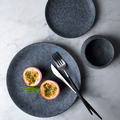 two pieces of fruit are on a plate with a fork and knife next to it