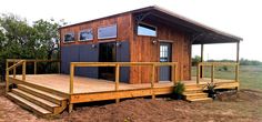 a small wooden house sitting on top of a dirt field