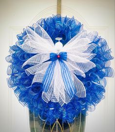 a blue and white wreath hanging on the front door