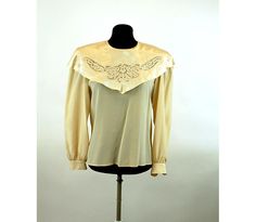 "This is a romantic 1980s blouse made of 100% silk with a large cape collar that is embroidered and features stunning open work. The ivory colored silk is so soft and luxurious! The satin collar gleams in the light. I love the small covered buttons down the back and at the cuffs. It is really an exquisite blouse! Made in the Philippines. Label is Belle Femme by Susan Trout. Size 8. It is generously size, like many blouses from the 80s. Please check measurements. Excellent condition. Measurements Cream Tops For Fall Wedding, Cream Tops For Wedding In Fall, Spring Wedding Vintage Blouse, Vintage Collar Blouse For Wedding, Vintage Silk Blouse For Evening, Vintage Cream Blouse For Wedding, Vintage Lace Trim Blouse For Evening, Elegant Embroidered Blouse With Peter Pan Collar, Vintage Tops For Fall Weddings