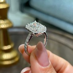 a person holding a diamond ring in their hand