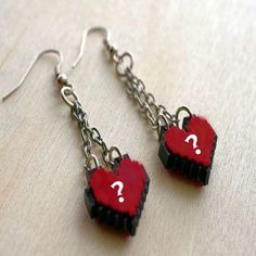 two red heart shaped earrings with the letter m on them