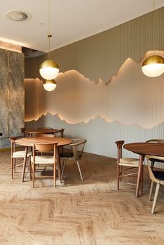 a dining room with wooden tables and chairs in front of a mountain wallpapered background