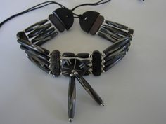 "Bone chokers are part of the Native American culture in almost every part of World. Worn as ornamentation and for protection. Wearing or carrying animal parts dates back more than 15,000 years and was believed to endow the wearer with the power of the creature. This choker has 4 rows of hairpipe beads carved from Buffalo Bone. The choker measures 14\" long with 9\" of leather tie's on both sides. Choker is packaged inside Organza Bag for storing or gift giving. Inside the bag is an Information Traditional Adjustable Black Beads Choker, Black Artisan Handmade Choker, Handmade Artisan Black Choker, Black Artisan Choker For Gift, Artisan Black Choker As A Gift, Artisan Black Choker For Gift, Black Adjustable Artisan Necklace, Traditional Black Adjustable Necklace, Traditional Adjustable Black Necklace