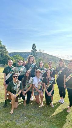 a group of people standing on top of a lush green field next to each other