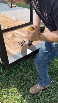 a man using a screwdriver to drill holes in the side of a trailer