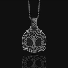 a necklace with an intricate design on the front and back side, hanging from a chain