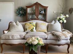 a living room filled with lots of furniture and flowers on top of the coffee table