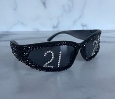 a pair of sunglasses with the number twenty two on it's side, sitting on a marble surface