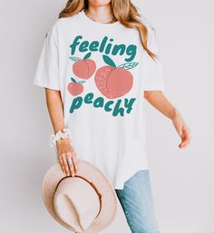 Stay fresh and flirty with this sweet "Feeling Peachy" tee, perfect for adding a pop of fruity fun to your style! We use professional quality DGT printing on all our apparel. Direct-to-garment, or DTG, is a high quality printing method that sprays ink directly onto the garment so there is no peeling or cracking. This fabulous graphic will be printed on a Comfort Colors Unisex T-Shirt. Please refer to the size charts in the images for the best fit.  Estimated Production Time: 1-5 days Estimated S Trendy Peach T-shirt With Letter Print, Cute Peach T-shirt With Crew Neck, Trendy Peach Top With Graphic Print, Casual Peach T-shirt With Letter Print, Spring Peach Crew Neck T-shirt, Trendy Peach Relaxed Fit T-shirt, Trendy Relaxed Fit Peach T-shirt, Spring Peach T-shirt With Graphic Print, Spring Peach Graphic Print T-shirt