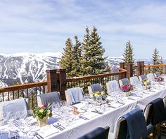 a long table is set up for an outdoor event with mountains in the back ground