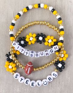 three beaded bracelets that say pittsburgh and football