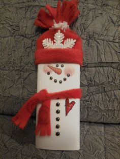 a snowman made out of toilet paper with a red hat and scarf on it