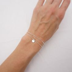 MADE WITH SOLID STERLING SILVER PARTS - A GREAT KEEPSAKEThis bracelet set features two beautiful pieces. The tiny sterling silver disc on one bracelet adds a dainty touch to a simple piece. The lightweight charm slides freely along the chain. The second bracelet features a simple sterling silver chain to complement the minimalist design. Comes in a gift box, perfect for gift giving. SIZING - IMPORTANT: To determine bracelet size, measure snugly around your wrist and add 1/2 inch to get your brac Delicate Adjustable Simple Bracelets, Simple Tiny Adjustable Bracelets, Mothers Birthstone Bracelet, Bracelet Set Silver, Disc Bracelet, Tiny Charm, Moms Bracelet, Bracelet Dainty, Bridesmaid Bracelet